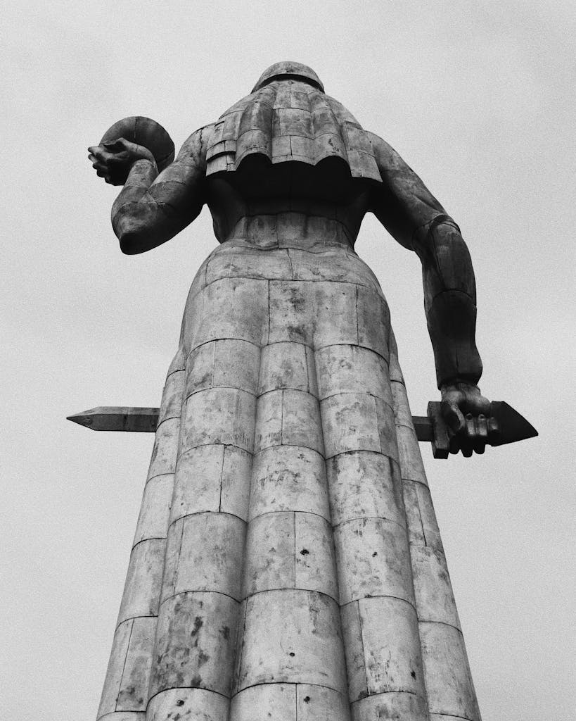 Low angle black and white photo of Kartlis Deda statue in Tbilisi, Georgia showcasing its iconic design.